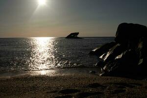 tramonto spiaggia nel capo Maggio nuovo maglia dove voi può ottenere un' grande Visualizza di il sole andando giù attraverso il oceano e il baia. il riflessione di il sole su il acqua con il affondata nave sembra così Bellissima. foto