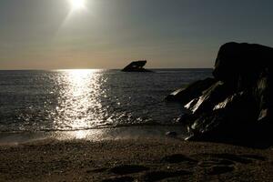 tramonto spiaggia nel capo Maggio nuovo maglia dove voi può ottenere un' grande Visualizza di il sole andando giù attraverso il oceano e il baia. il riflessione di il sole su il acqua con il affondata nave sembra così Bellissima. foto