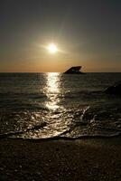 tramonto spiaggia nel capo Maggio nuovo maglia dove voi può ottenere un' grande Visualizza di il sole andando giù attraverso il oceano e il baia. il riflessione di il sole su il acqua con il affondata nave sembra così Bellissima. foto