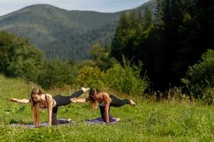 fitness donne nel triangolo posa mentre praticando yoga a un' parco. foto