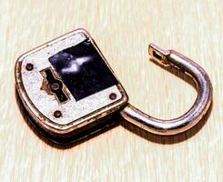 un' lucchetto con un' chiave su un' di legno superficie foto