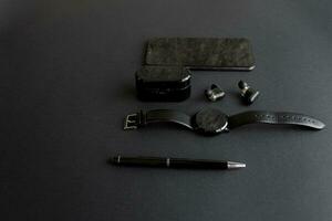 nero penna, nero inteligente guarda, smartphone, senza fili cuffie su buio sfondo foto