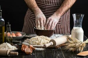 contro il sfondo di Uomini mani impastare il Impasto. ingredienti per cucinando Farina prodotti o Impasto pane, muffin, torta, Pizza Impasto . foto