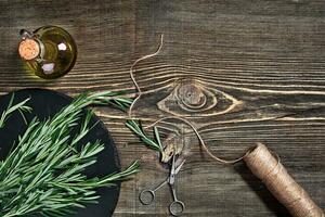 rami di rosmarino su grigio di legno tavolo. rosmarino su taglio tavola. rustico stile, fresco biologico erbe aromatiche. foto