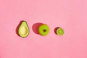 metà avocado frutta Mela su rosa sfondo foto