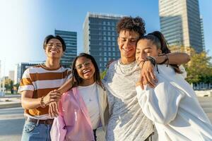 internazionale gruppo di allegro adolescenti ridendo e abbracciare amorevolmente nel il strada. foto