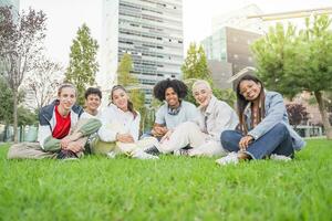 gruppo di multietnico amici avendo divertimento insieme con se stesso ritratto su erba nel il parco. foto