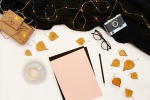 romantico autunno finto su. foglio di rosa carta, giallo e arancia foglie, matite, tazza di cappuccino e vecchio fotocamera.top Visualizza. piatto posizione. foto