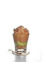 ghiacciato avocado caffè, fresco miscelato avocado versato uno tiro di caffè espresso nel un' plastica tazza su un' di legno sottobicchiere foto