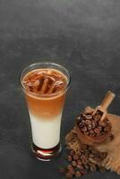 nero ghiaccio caffè e ghiaccio latte macchiato caffè con latte nel alto bicchiere isolato su bianca e nero sfondo foto