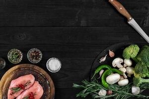 crudo pollo Seno filetti su di legno taglio tavola con erbe aromatiche e spezie. superiore Visualizza con copia spazio foto