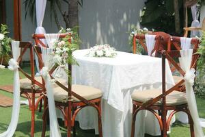 nozze altare e riga di Marrone e bianca sedie tiro a Basso angolo preparato su il bellissimo parco o giardino foto