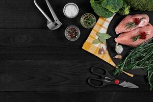 crudo pollo filetto con cucinando ingredienti su nero ardesia tavolo. cibo sfondo. superiore Visualizza, copia spazio. foto