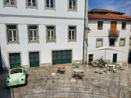 un' cortile con un' verde auto parcheggiata nel davanti di un' edificio foto