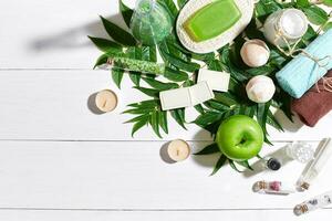 terme impostato con asciugamano e sapone su bianca di legno sfondo con verde le foglie foto