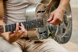 un' uomo è giocando un acustico chitarra foto