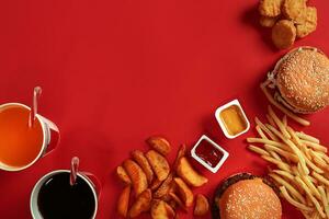 veloce cibo piatto superiore Visualizza. carne hamburger, Patata patatine fritte e bicchiere di bevanda su rosso sfondo. porta via composizione. foto