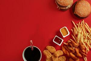 veloce cibo piatto superiore Visualizza. carne hamburger, Patata patatine fritte e bicchiere di bevanda su rosso sfondo. porta via composizione. foto