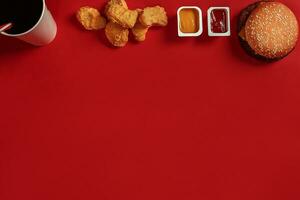hamburger e pepite. veloce cibo su rosso sfondo. foto