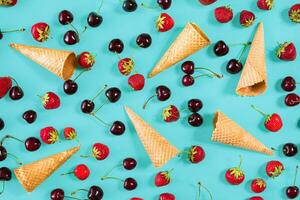 frutti di bosco nel cialda coni - fragola e nero ciliegia su blu ba foto