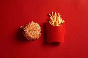 concetto di finto su hamburger e francese patatine fritte su rosso sfondo. copia spazio per testo e logo. foto