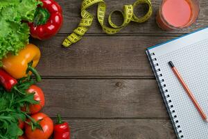 sport e dieta. verdure e centimetro. peperoni, pomodori, insalata su rustico sfondo foto