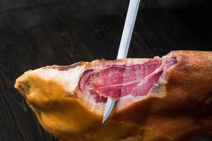 jamon. jamon serrano. tradizionale spagnolo prosciutto su nero vicino su. foto