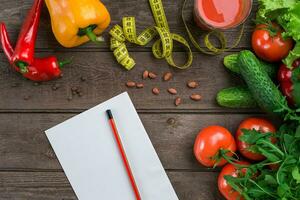 bicchiere di pomodoro succo con verdure e misurazione nastro su tavolo avvicinamento foto