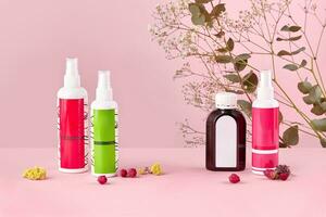tre colorato cosmetico pompa bottiglie e Marrone contenitore con il branding la zona, secco fiori contro rosa studio sfondo. vicino su, copia spazio foto