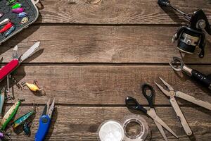 pesca affrontare - pesca Filatura, pesca linea, ganci e esche su di legno sfondo. foto