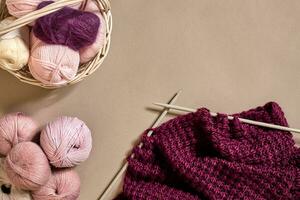 palle di merino lana filato, maglieria su maglieria aghi su un' beige superficie. superiore Visualizza foto