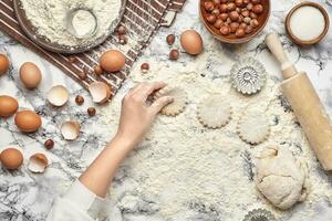 avvicinamento sparo. superiore Visualizza di un' panettiere cucinare posto, mani siamo Lavorando con un' crudo Impasto su il marmo tavolo sfondo. foto