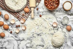 avvicinamento sparo. superiore Visualizza di un' cottura al forno ingredienti e utensili da cucina su il marmo tavolo sfondo. foto