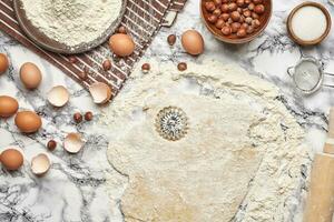 avvicinamento sparo. superiore Visualizza di un' cottura al forno ingredienti e utensili da cucina su il marmo tavolo sfondo. foto