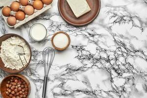 avvicinamento sparo. superiore Visualizza di un' cottura al forno ingredienti e utensili da cucina su il marmo tavolo sfondo. foto