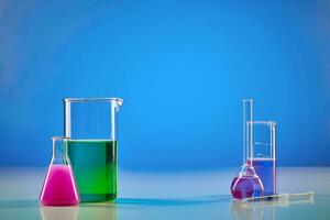 medico fiaschi e Due bicchieri, colorato chimico reagenti per prove, blu sfondo. laboratorio ricerca di coronavirus. In tutto il mondo pandemia covid-19 foto