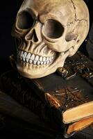 realistico modello di un' umano cranio con denti su un' di legno buio tavolo, nero sfondo. medico scienza o Halloween orrore concetto. avvicinamento sparo. foto