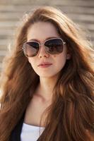 bella giovane donna con occhiali da sole alla moda foto
