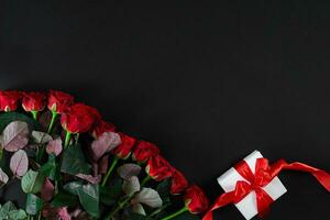 rosso Rose e bianca regalo scatola con rosso nastro su nero sfondo foto