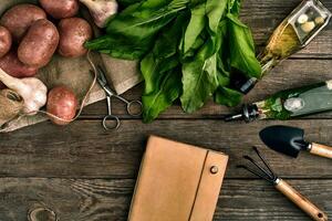 fresco patate, olio, aglio e speziato erbe aromatiche su un' cucina di legno sfondo. fresco verdure a partire dal il tuo proprio giardino. foto