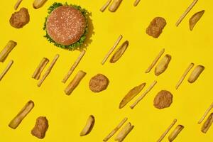 maggior parte popolare veloce cibo pasto. pollo pepite, hamburger e francese patatine fritte su giallo sfondo superiore Visualizza foto