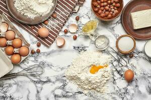 avvicinamento sparo. superiore Visualizza di un' cottura al forno ingredienti e utensili da cucina su il marmo tavolo sfondo. foto