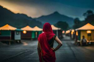 un' donna nel un' rosso sari sta nel il mezzo di un' strada a notte. ai-generato foto