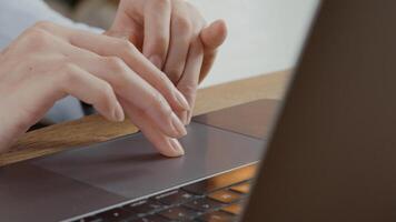 primo piano delle dita della giovane donna che si spostano sul touch pad del laptop foto