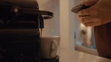 mano dell'uomo che tiene smartphone e caffè a corto di macchina foto