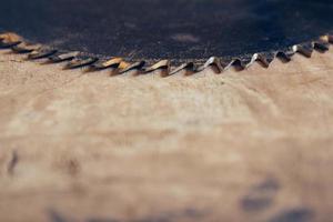 sega circolare a lama tonda sullo sfondo del tavolo in legno foto