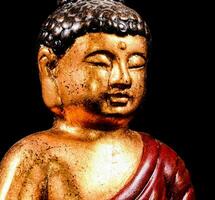 un' statua di un' Budda con un' rosso accappatoio foto