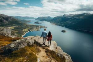 coppia a piedi su superiore di montagna e guardare a fiordo nel Norvegia, posteriore Visualizza di coppia famiglia in viaggio insieme su scogliera bordo nel Norvegia, ai generato foto