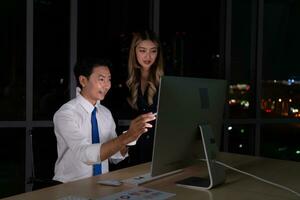 tutti e due di giovane asiatico broker internazionale azione commercianti Lavorando insieme su del desktop a notte ufficio, internazionale finanziario investimento azienda concetto foto
