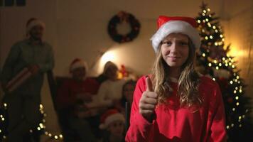 ritratto di adolescenziale ragazza nel Santa cappello seduta su sedia nel davanti di Natale albero, allegro Natale e contento vacanze foto